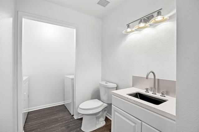 bathroom with hardwood / wood-style flooring, vanity, and toilet