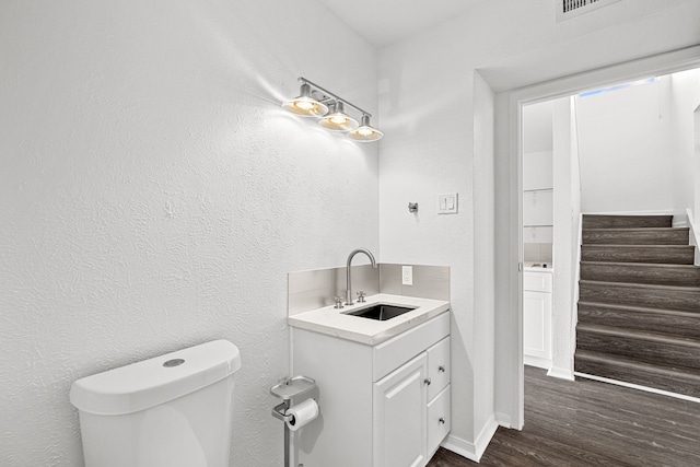 bathroom with vanity, wood-type flooring, and toilet