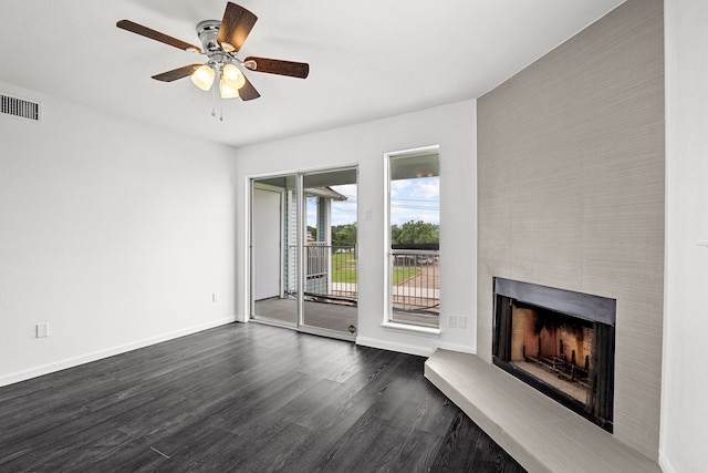 unfurnished living room featuring dark hardwood / wood-style floors, ceiling fan, and a fireplace