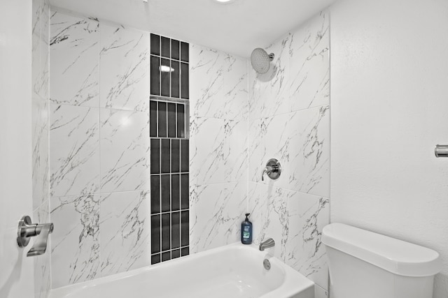 bathroom with tiled shower / bath combo and toilet