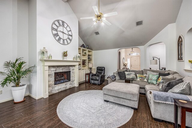 living room featuring high vaulted ceiling, ceiling fan, a stone fireplace, and hardwood / wood-style flooring