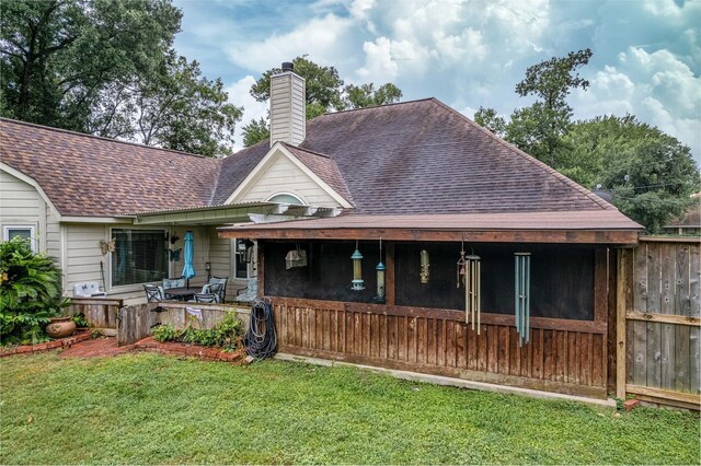 back of house featuring a lawn