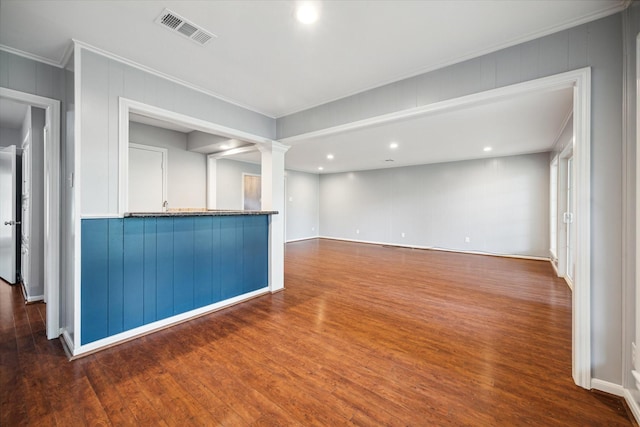 unfurnished room featuring dark hardwood / wood-style flooring, crown molding, and ornate columns