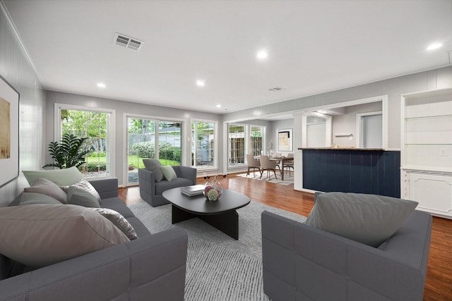 living room with dark hardwood / wood-style flooring and ornate columns