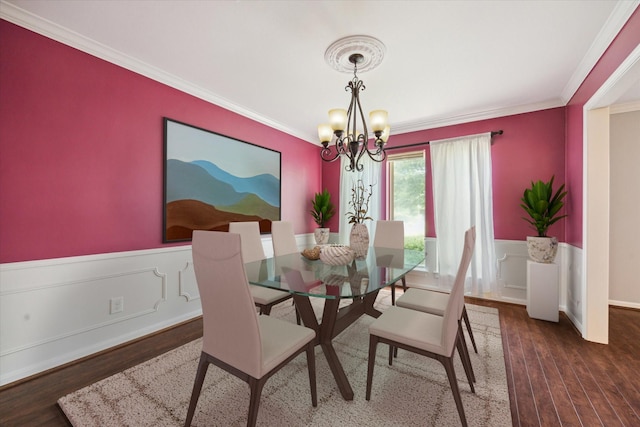 dining room with dark wood-type flooring, ornamental molding, and a chandelier