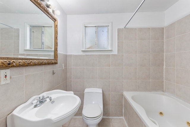 full bathroom with tile patterned floors, tiled shower / bath combo, sink, and tile walls