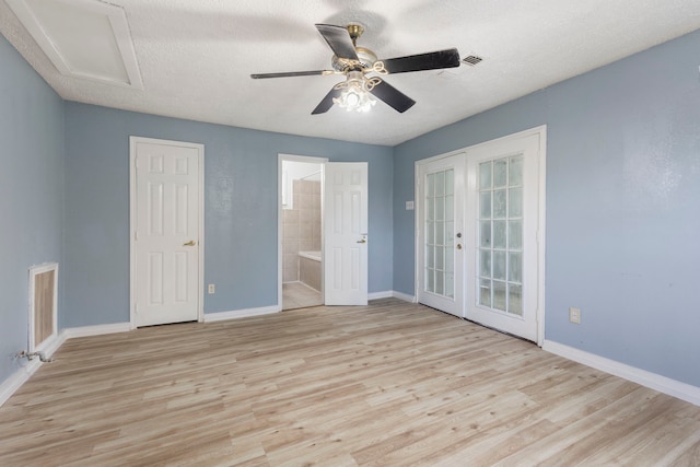 unfurnished bedroom featuring french doors, ceiling fan, light wood-type flooring, a textured ceiling, and connected bathroom