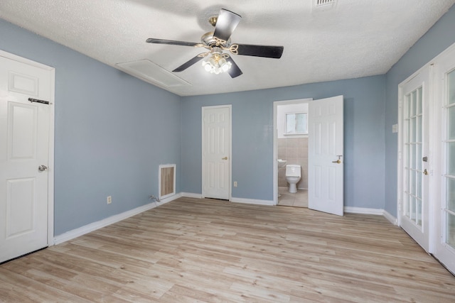 unfurnished bedroom featuring a textured ceiling, ensuite bathroom, ceiling fan, and light hardwood / wood-style floors