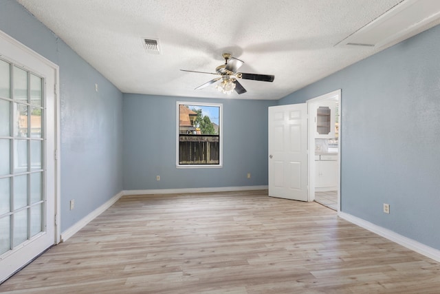 spare room featuring a textured ceiling, light hardwood / wood-style flooring, and ceiling fan