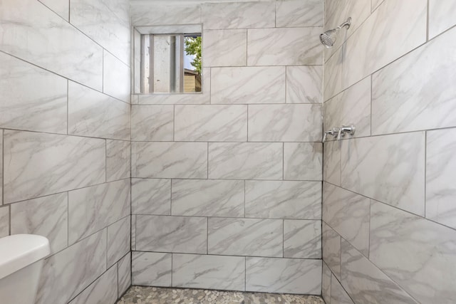 bathroom featuring toilet and tiled shower