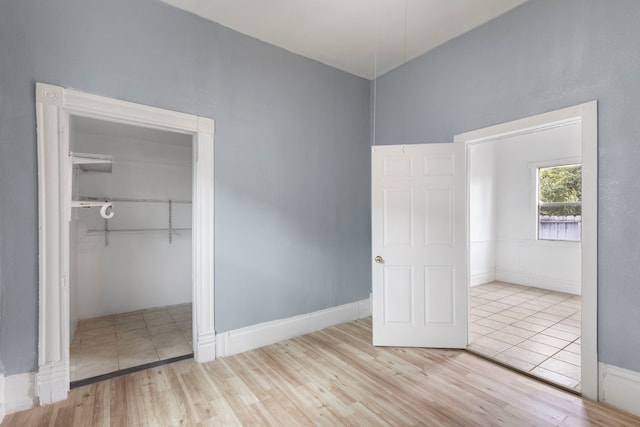 unfurnished bedroom featuring light hardwood / wood-style flooring and a closet