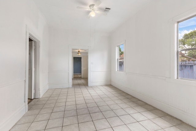 tiled spare room featuring ceiling fan