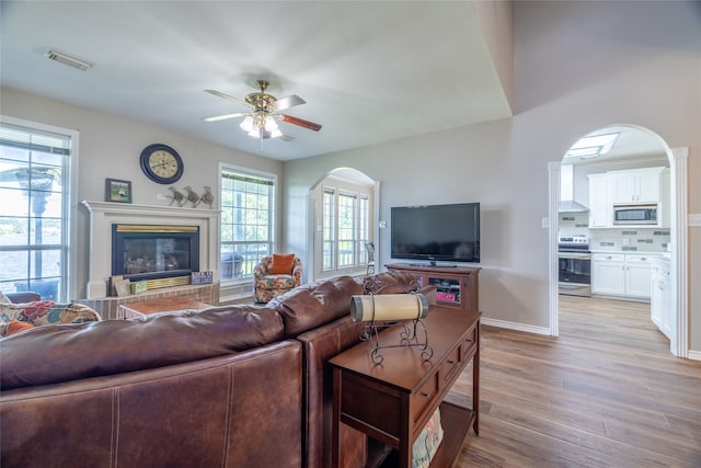 living room with light hardwood / wood-style floors and ceiling fan