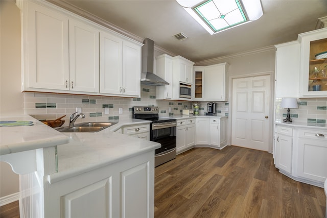 kitchen featuring white cabinets, wall chimney range hood, light stone counters, kitchen peninsula, and stainless steel appliances