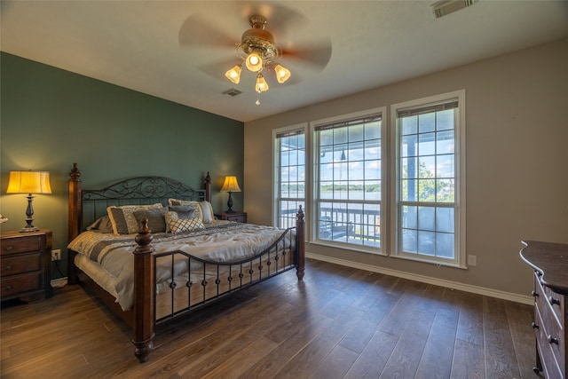 bedroom with dark hardwood / wood-style flooring and ceiling fan