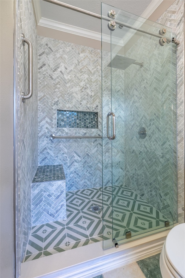 bathroom with tile patterned flooring, toilet, a shower with door, and crown molding