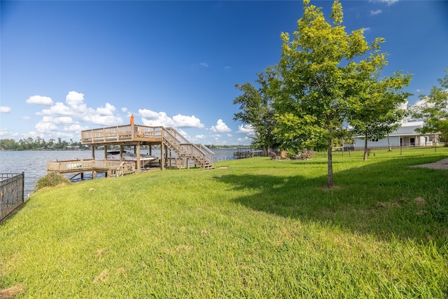 view of dock with a deck with water view and a lawn