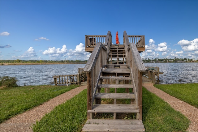 dock area with a lawn and a water view