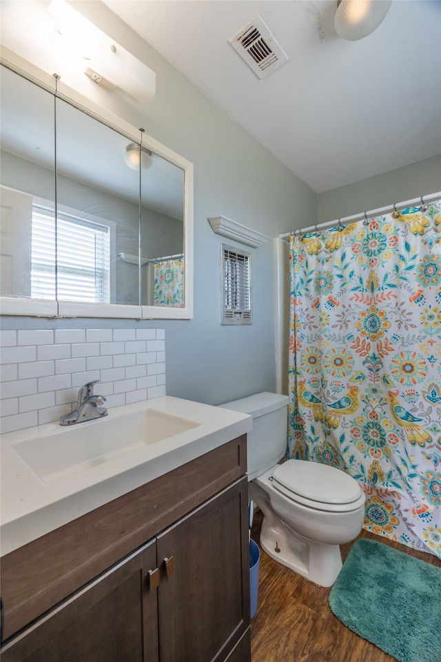 bathroom featuring decorative backsplash, toilet, vanity, and hardwood / wood-style flooring