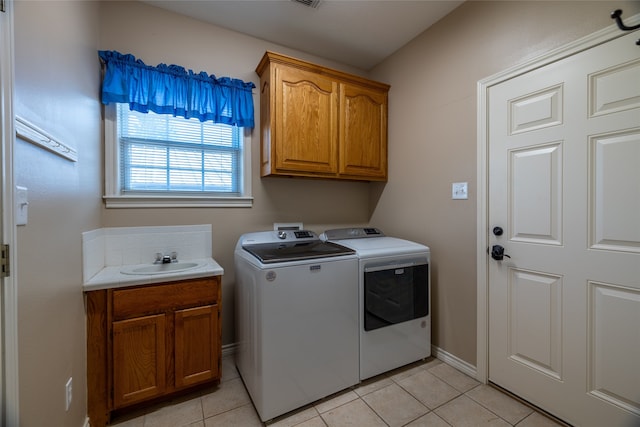 washroom featuring sink, light tile patterned floors, cabinets, and independent washer and dryer