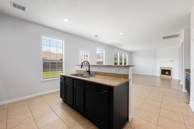 kitchen featuring a sink, visible vents, dishwasher, and dark cabinetry