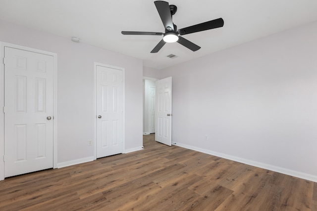 unfurnished bedroom with visible vents, baseboards, and wood finished floors