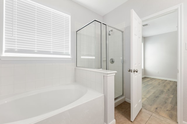 bathroom with tile patterned floors, visible vents, a shower stall, baseboards, and a bath