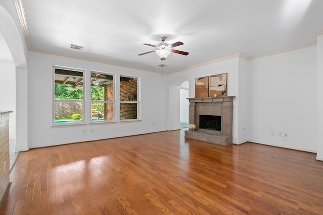 unfurnished living room with hardwood / wood-style floors, ceiling fan, ornamental molding, and a premium fireplace