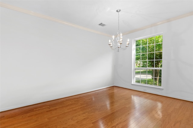 spare room with a chandelier, wood-type flooring, and ornamental molding