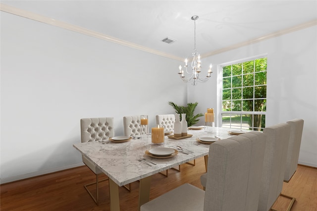 dining room with ornamental molding, a notable chandelier, and hardwood / wood-style flooring