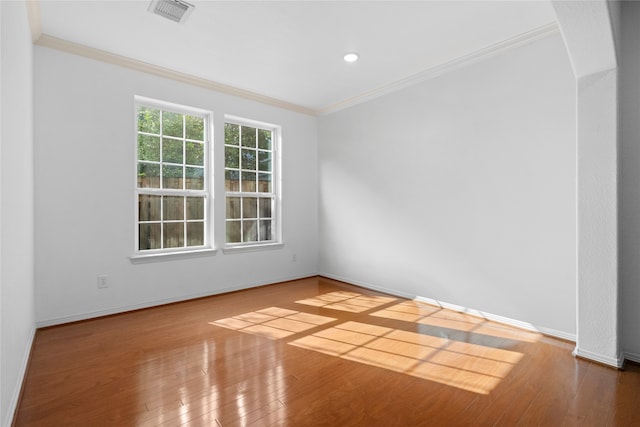 spare room with hardwood / wood-style floors and crown molding