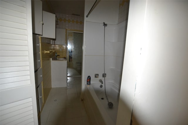 bathroom featuring tile patterned floors, shower / bathtub combination, and tile walls