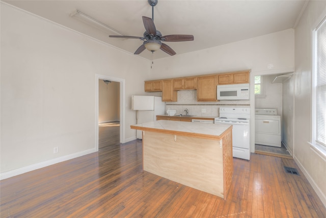 kitchen featuring dark hardwood / wood-style flooring, white appliances, sink, tile countertops, and washer / dryer