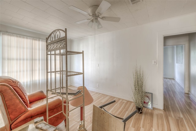 sitting room featuring ceiling fan, ornamental molding, and light hardwood / wood-style flooring