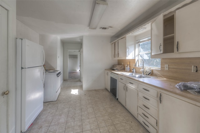 kitchen featuring backsplash, white appliances, sink, light tile patterned floors, and white cabinets