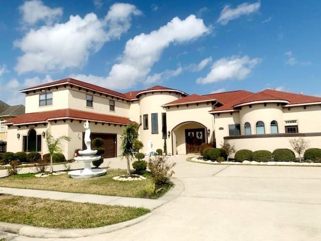 mediterranean / spanish-style house with a garage