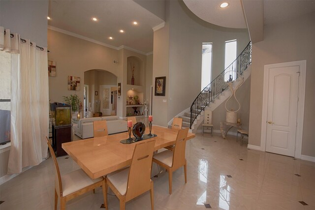 dining space with a high ceiling and ornamental molding