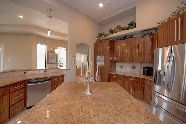 kitchen with decorative backsplash, hanging light fixtures, stainless steel appliances, and a textured ceiling