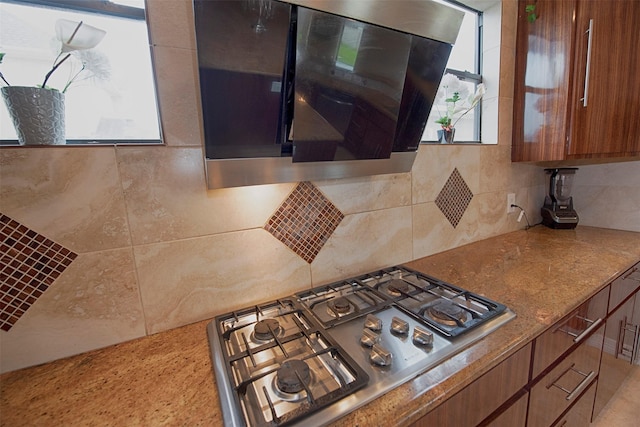 kitchen featuring stainless steel gas stovetop, extractor fan, and tasteful backsplash