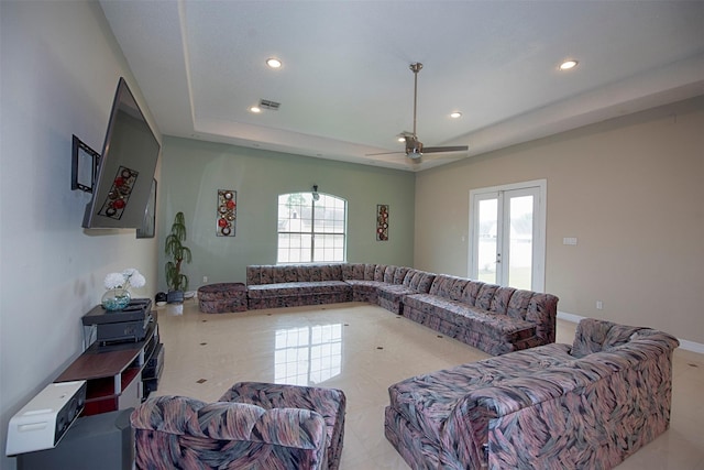 living room featuring ceiling fan, french doors, a wealth of natural light, and a tray ceiling