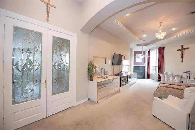 living room with a raised ceiling, light colored carpet, french doors, and a notable chandelier