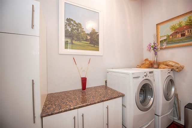 washroom with washer and dryer and cabinets