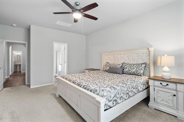 carpeted bedroom with connected bathroom and ceiling fan