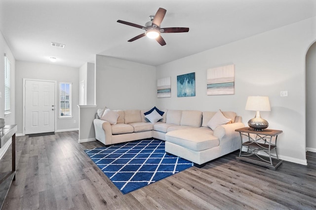 living room with ceiling fan and dark wood-type flooring