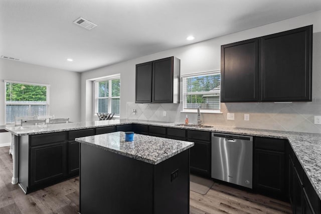 kitchen featuring light hardwood / wood-style floors, a center island, stainless steel dishwasher, and sink