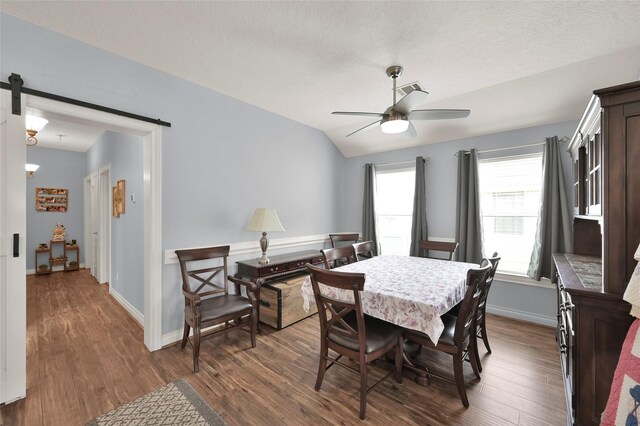 dining area with a barn door, a textured ceiling, hardwood / wood-style flooring, and ceiling fan