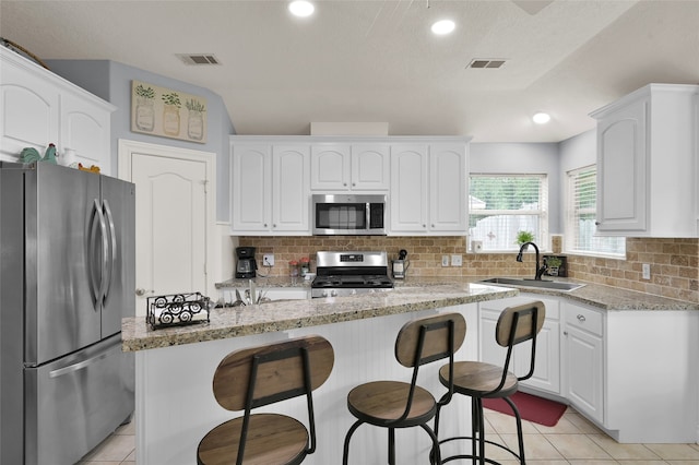 kitchen featuring white cabinetry, tasteful backsplash, stainless steel appliances, and light tile patterned floors