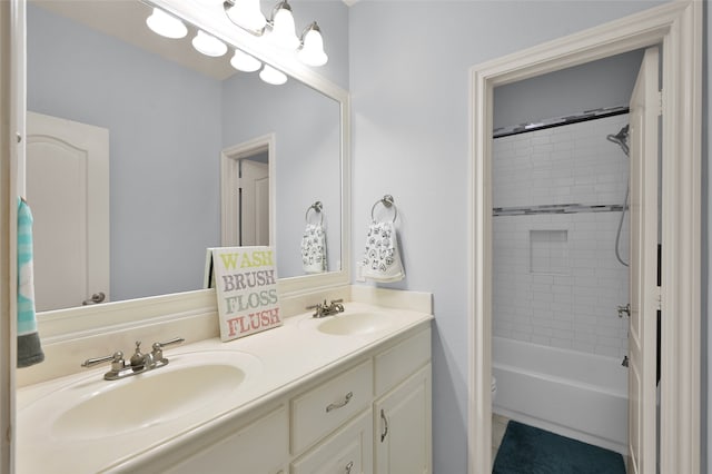 bathroom featuring dual vanity and tiled shower / bath