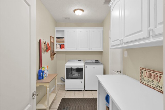 laundry area with cabinets, washer and dryer, and light tile patterned floors