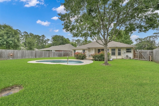 exterior space with a fenced in pool and a lawn